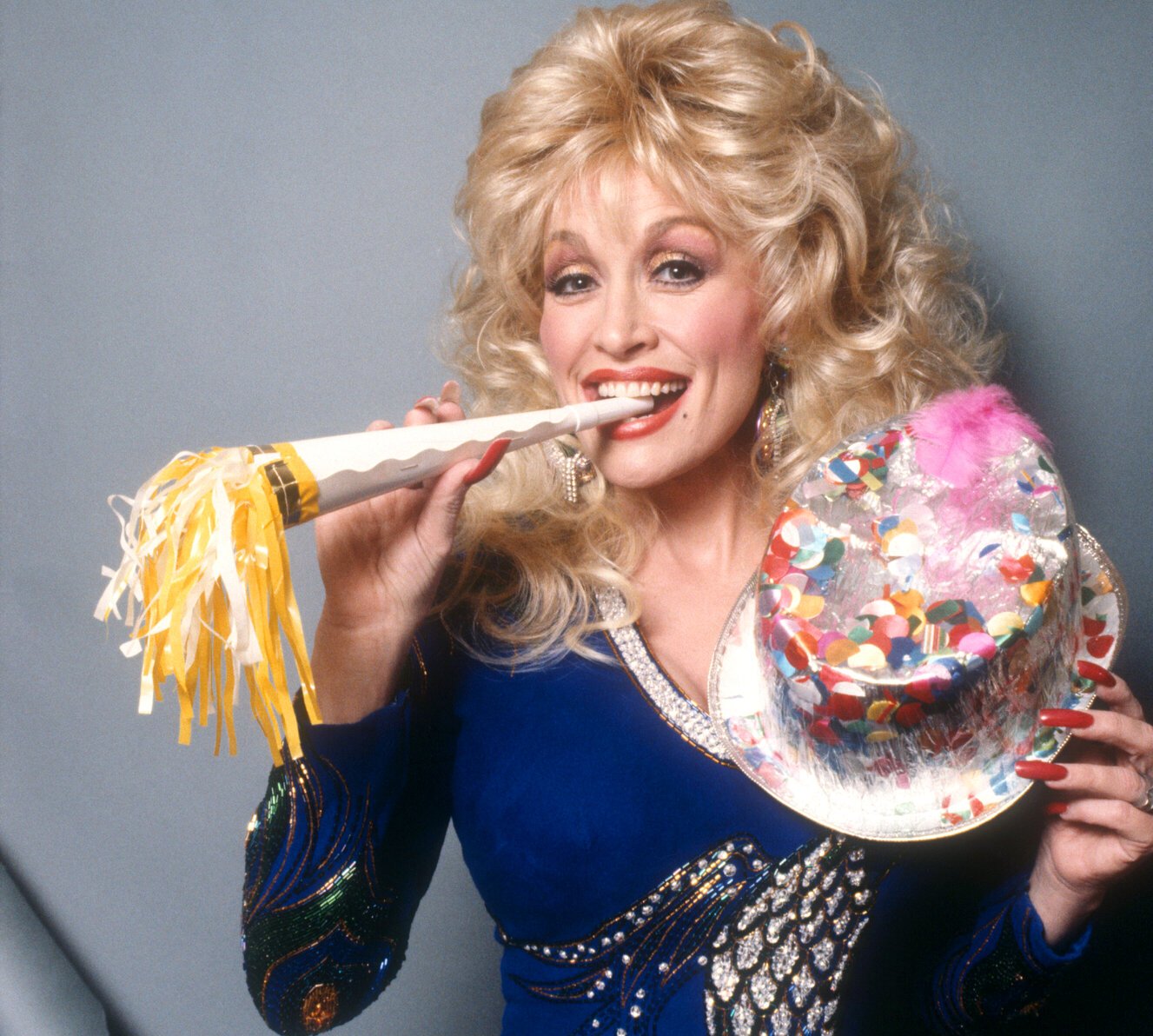 Dolly Parton with a party hat and noise maker in the 1990s.