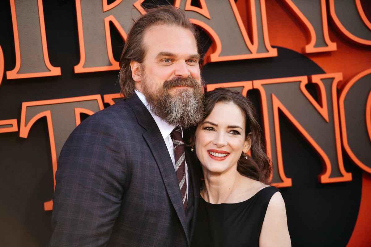 David Harbour in a black suit hugging Winona Ryder in a black dress at the 'Stranger Things' 3 premiere.