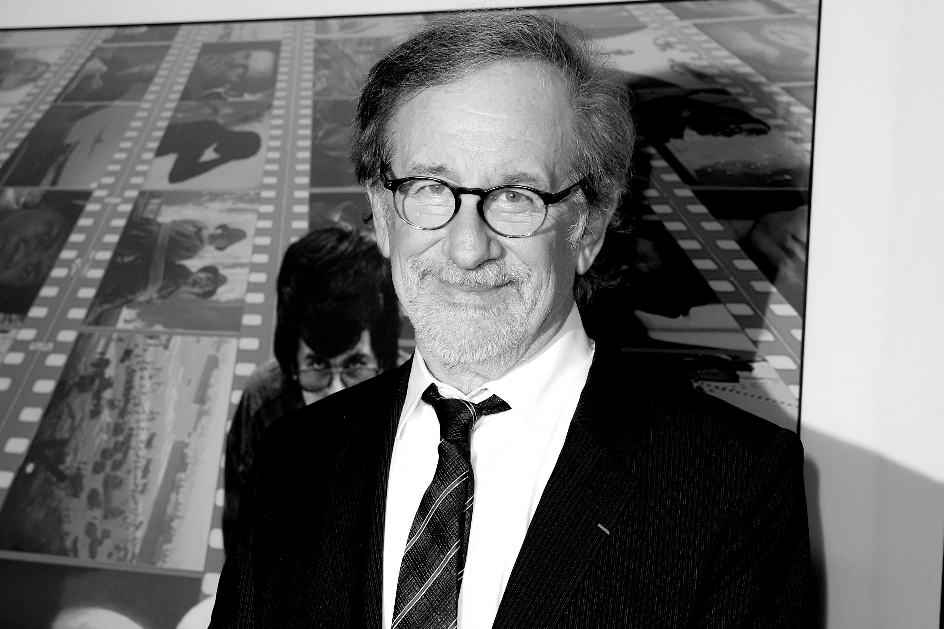 Steven Spielberg wearing a suit and glasses