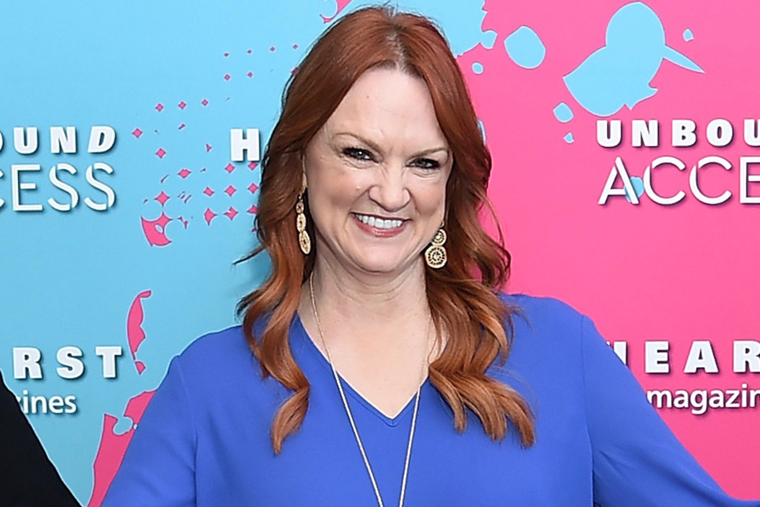 Ree Drummond smiling wearing a blue shirt as she poses for cameras