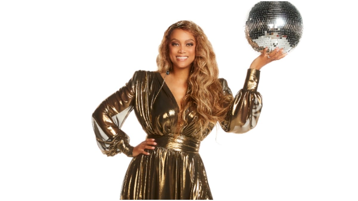 Tyra Banks holds a disco ball in DWTS promo.