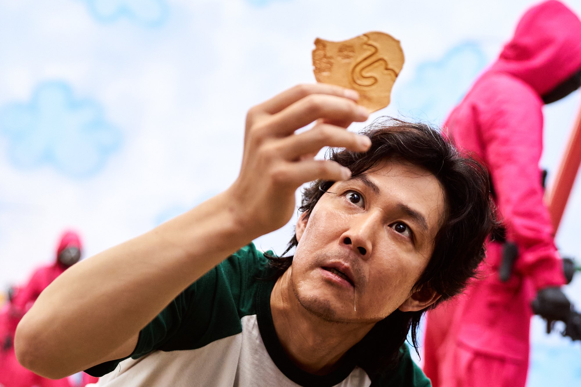 Actor Lee Jung-jae holding a cookie in 'Squid Game' Season 1.