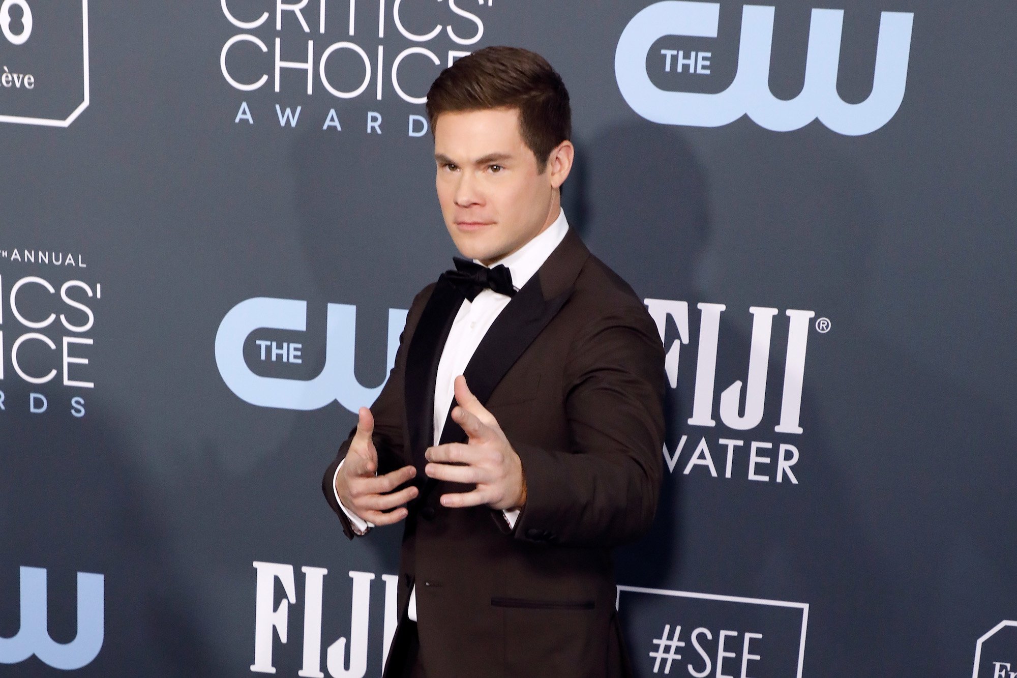 Adam Devine making finger guns on the red carpet