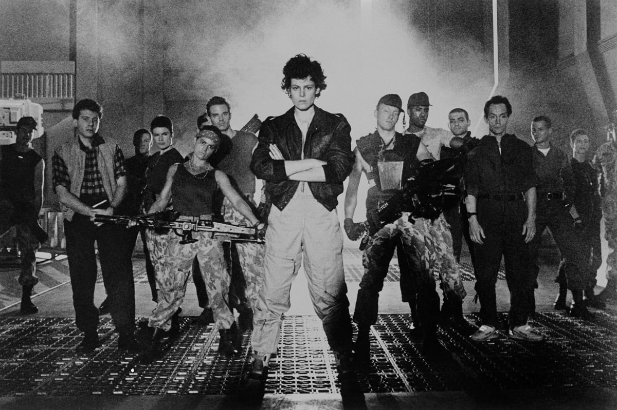 Sigourney Weaver and the cast of 'Aliens' looking at the camera.