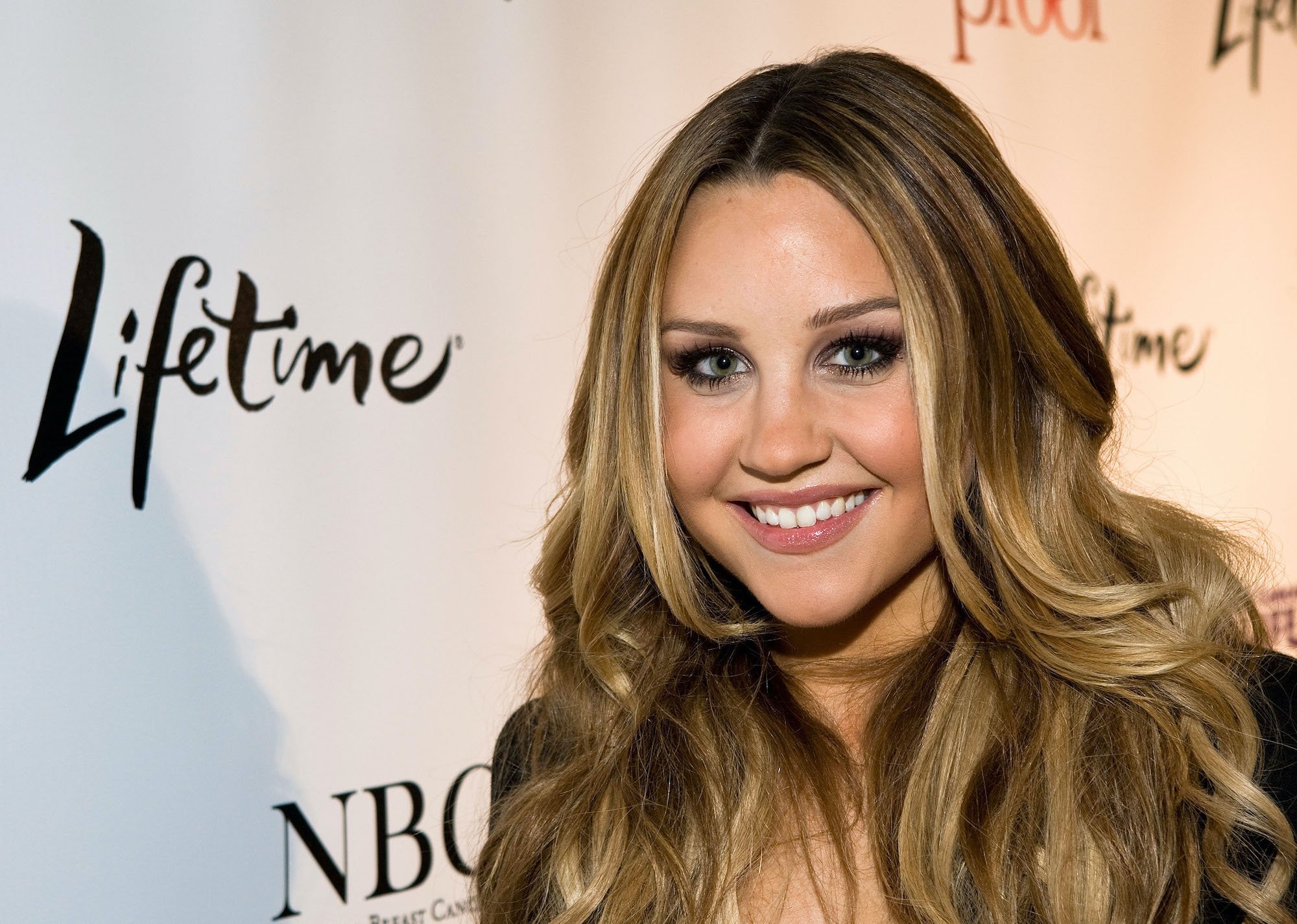 Amanda Bynes smiling in front of a white background