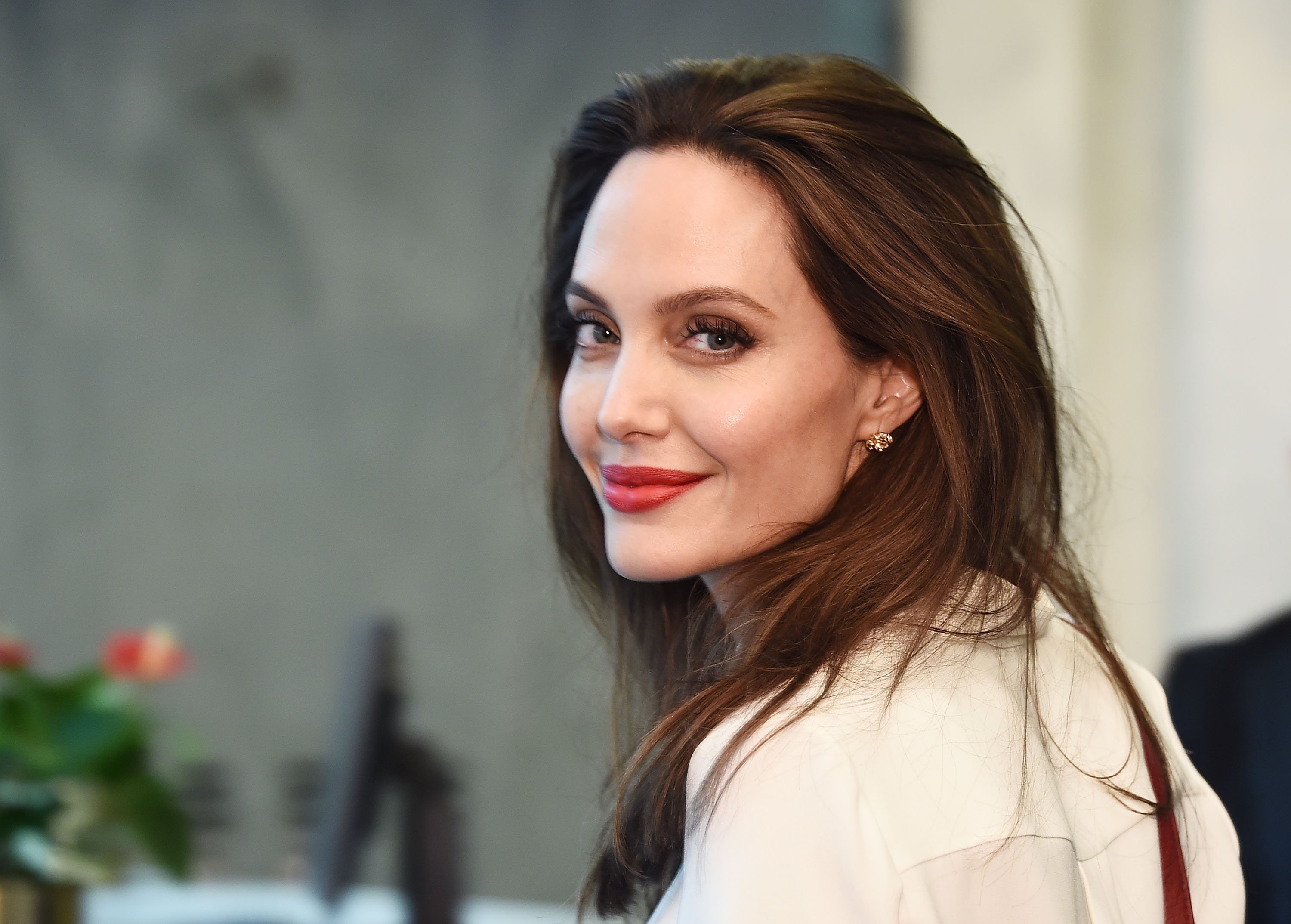 'Eternals' actor Angelina Jolie sports a red lip and a white shirt.