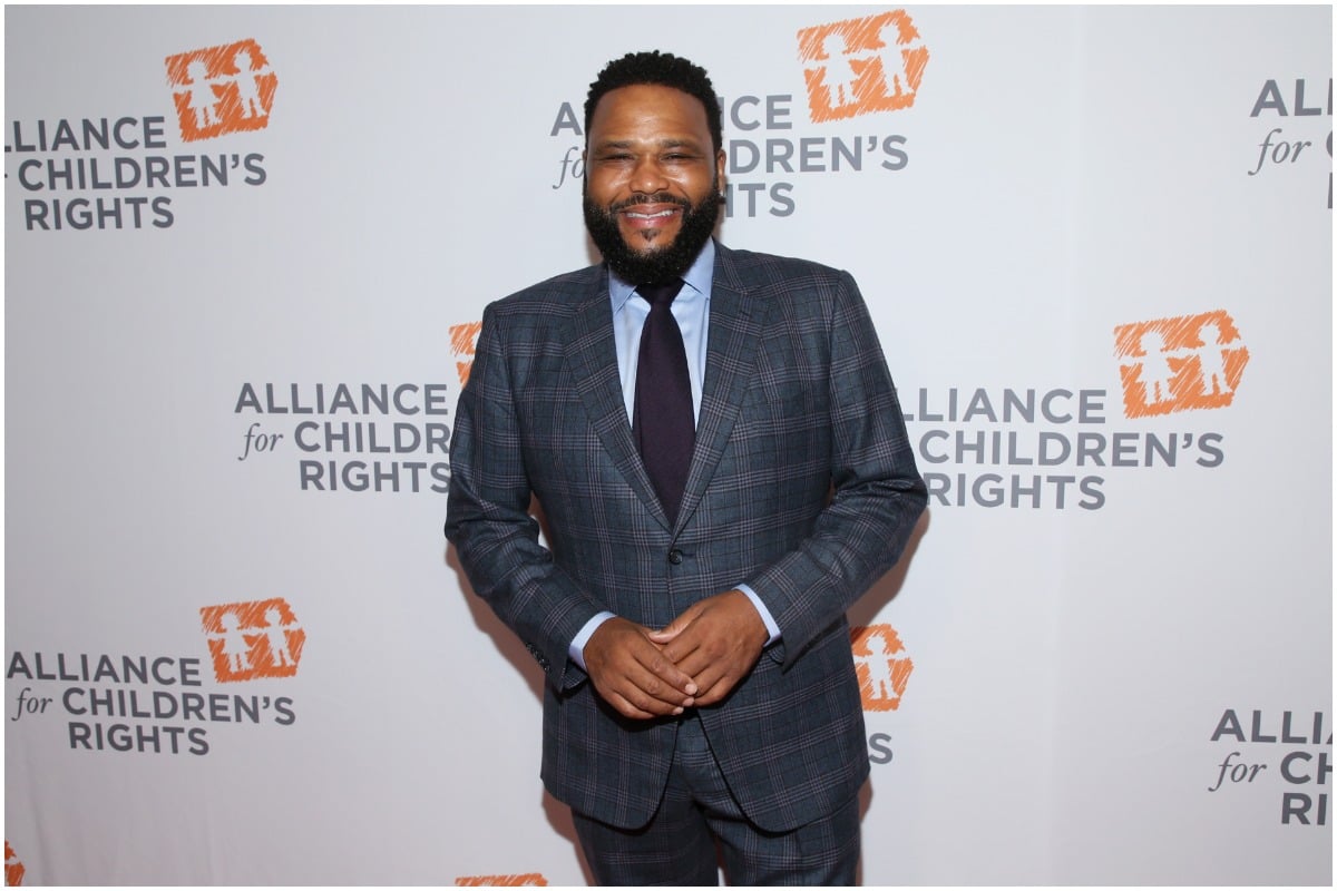 Anthony Anderson standing on the red carpet smiling.