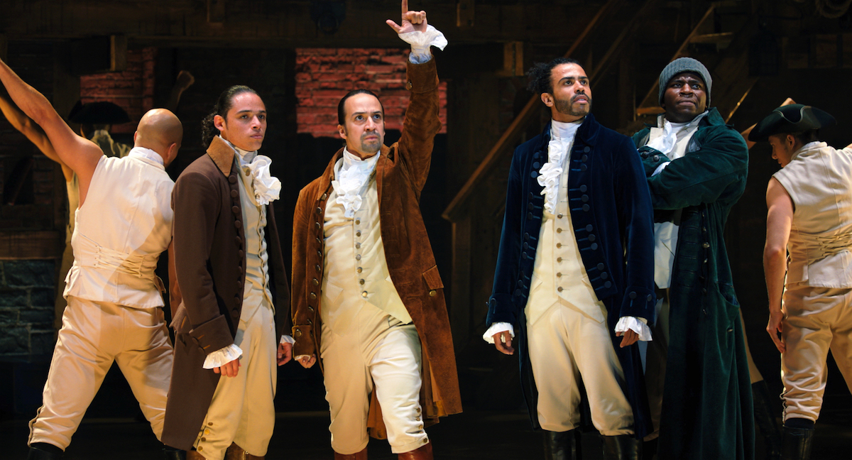 Anthony Ramos, Lin-Manuel Miranda, David Diggs, and Okieriete Onaodowan singing onstage in 'Hamilton'.