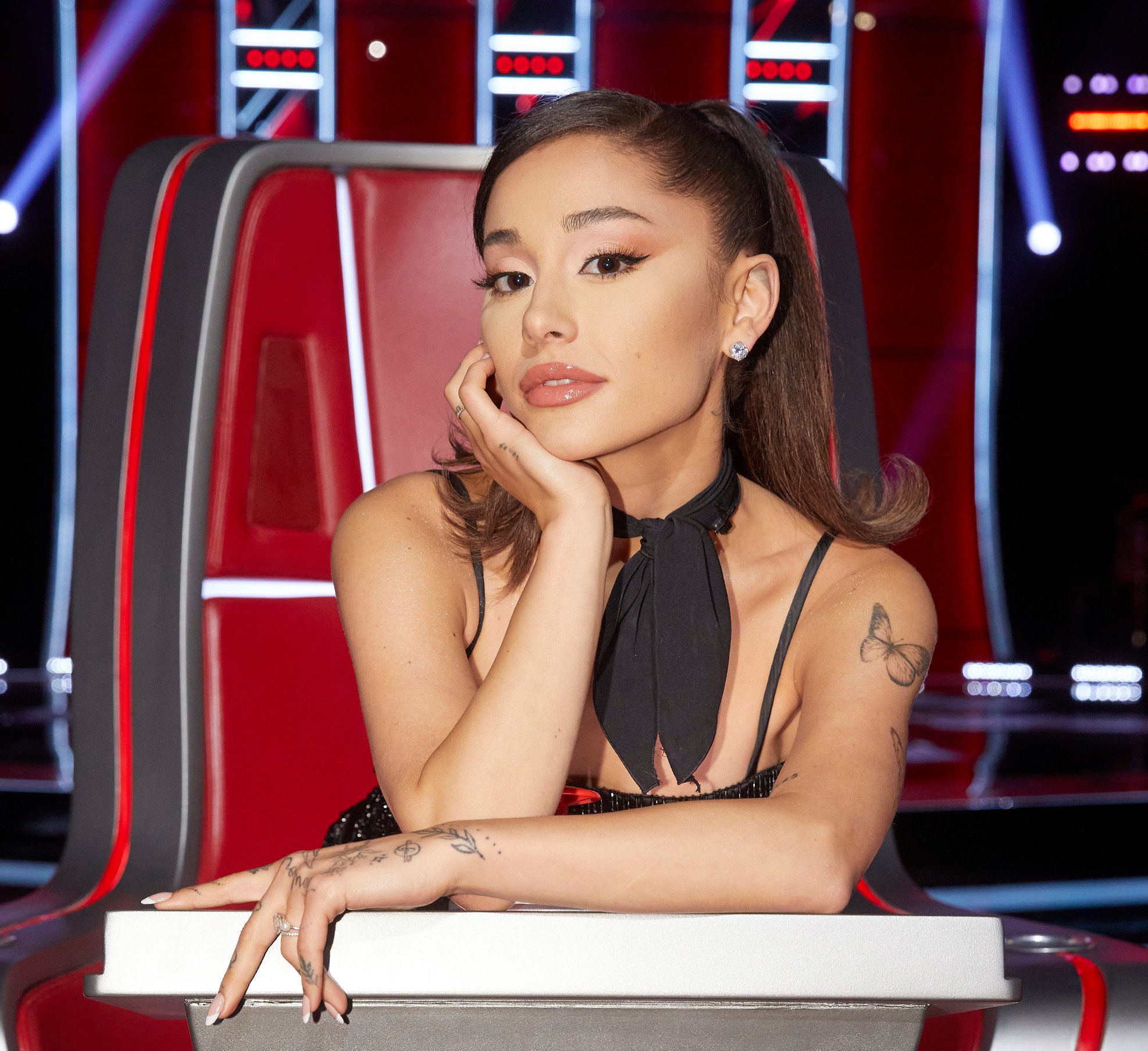 Ariana Grande posing in the judges' seat on NBC's 'The Voice' Season 21