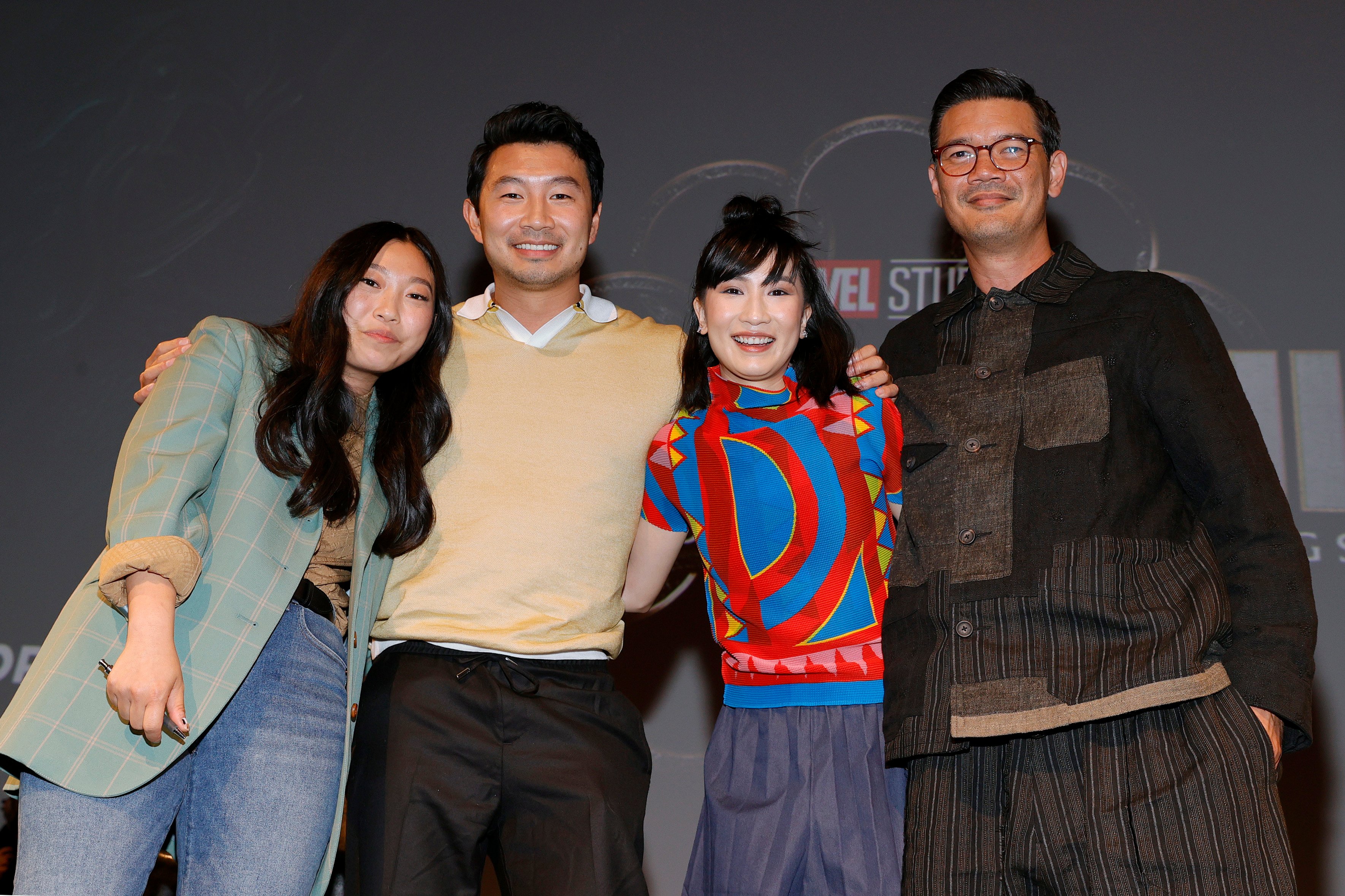 Awkwafina, Simu Liu, Meng'er Zhang and Destin Daniel Cretton standing together in front of a black background.