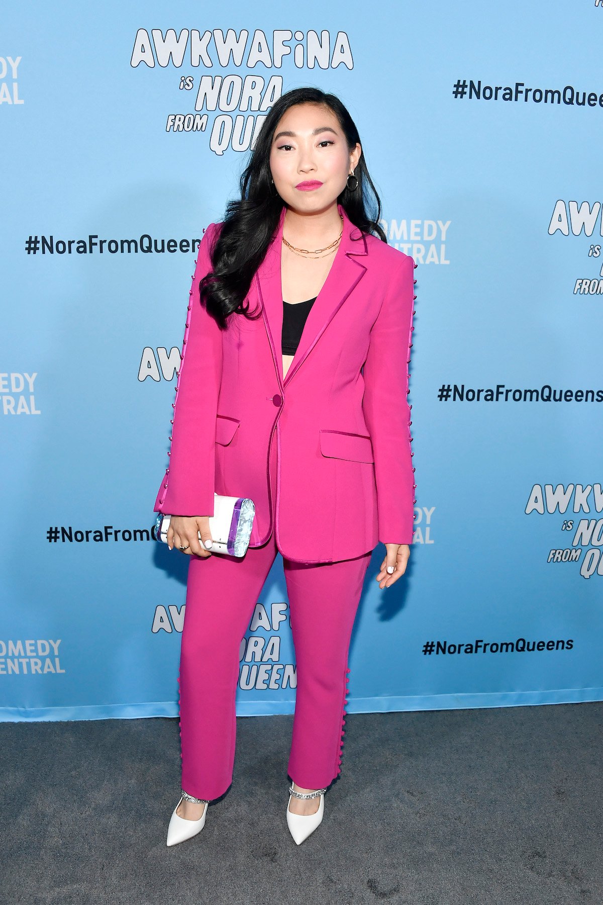 Awkwafina poses for cameras in a pink suit at the premiere of 'Awkwafina Is Nora From Queens'