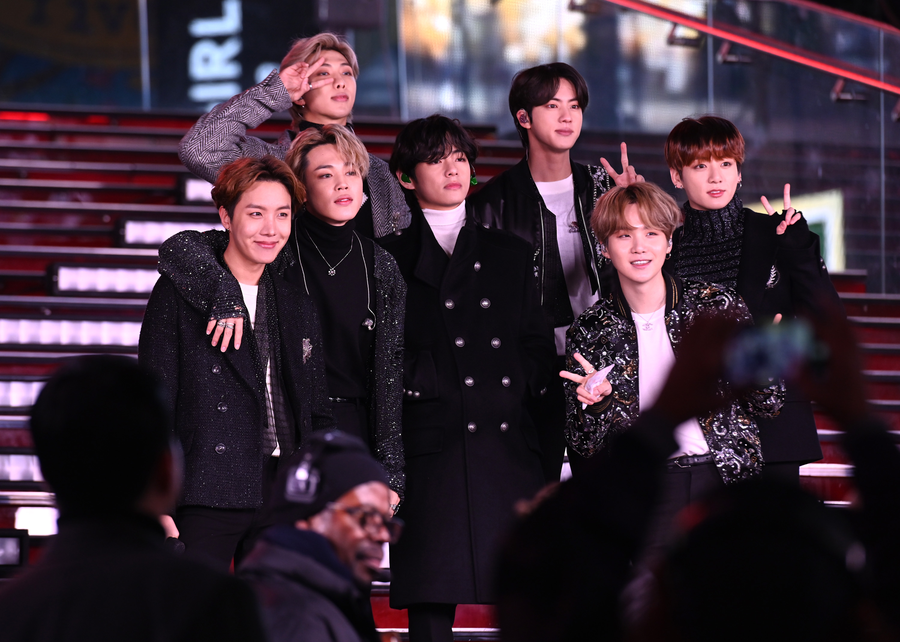 J-Hope, Jimin, RM, V, Jin, Suga, and Jungkook of BTS smile in Times Square