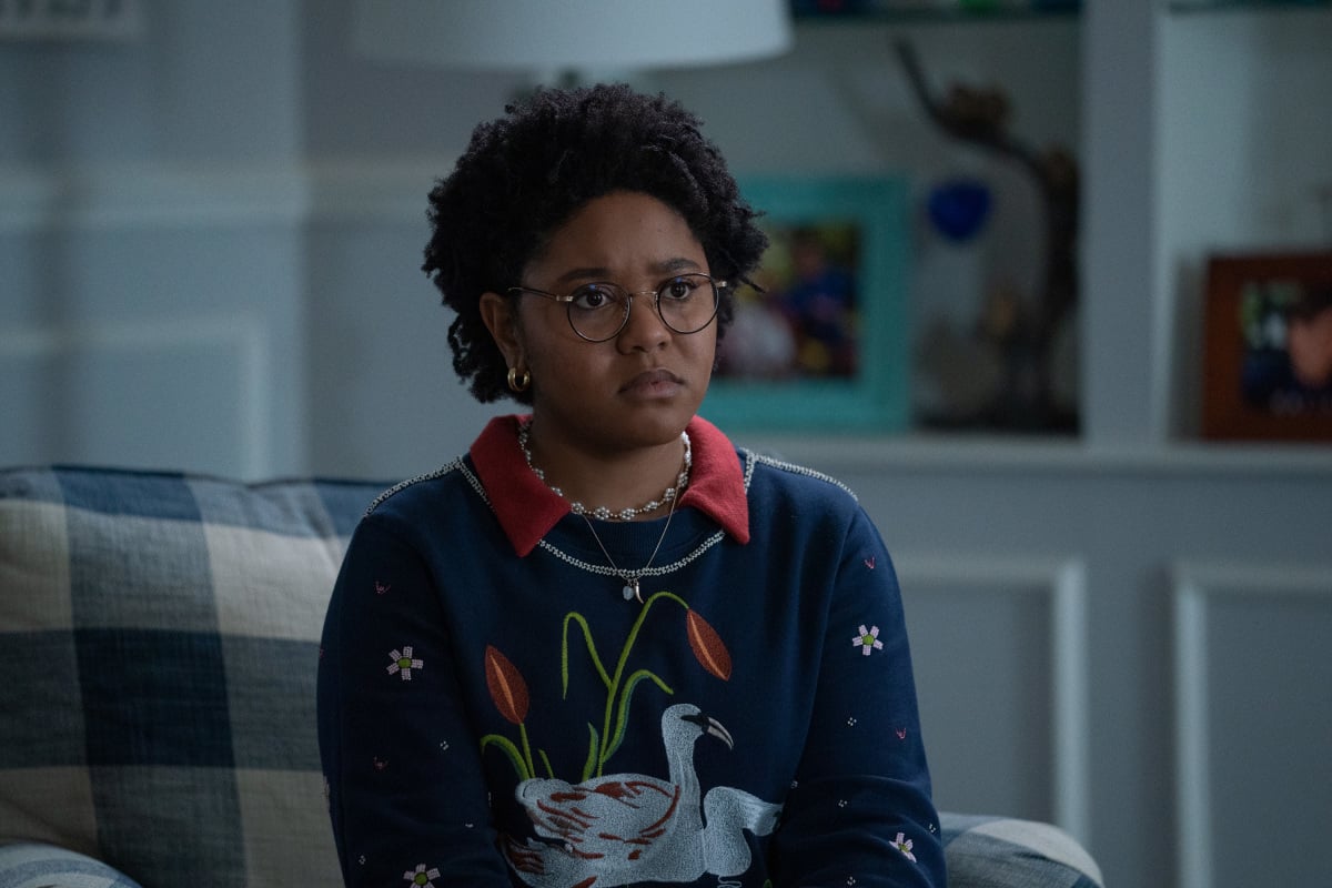 'Stargirl' actor Anjelika Washington, as her character Beth Chapel, wears a blue sweater with a swan and red tulips on it and a red collar.