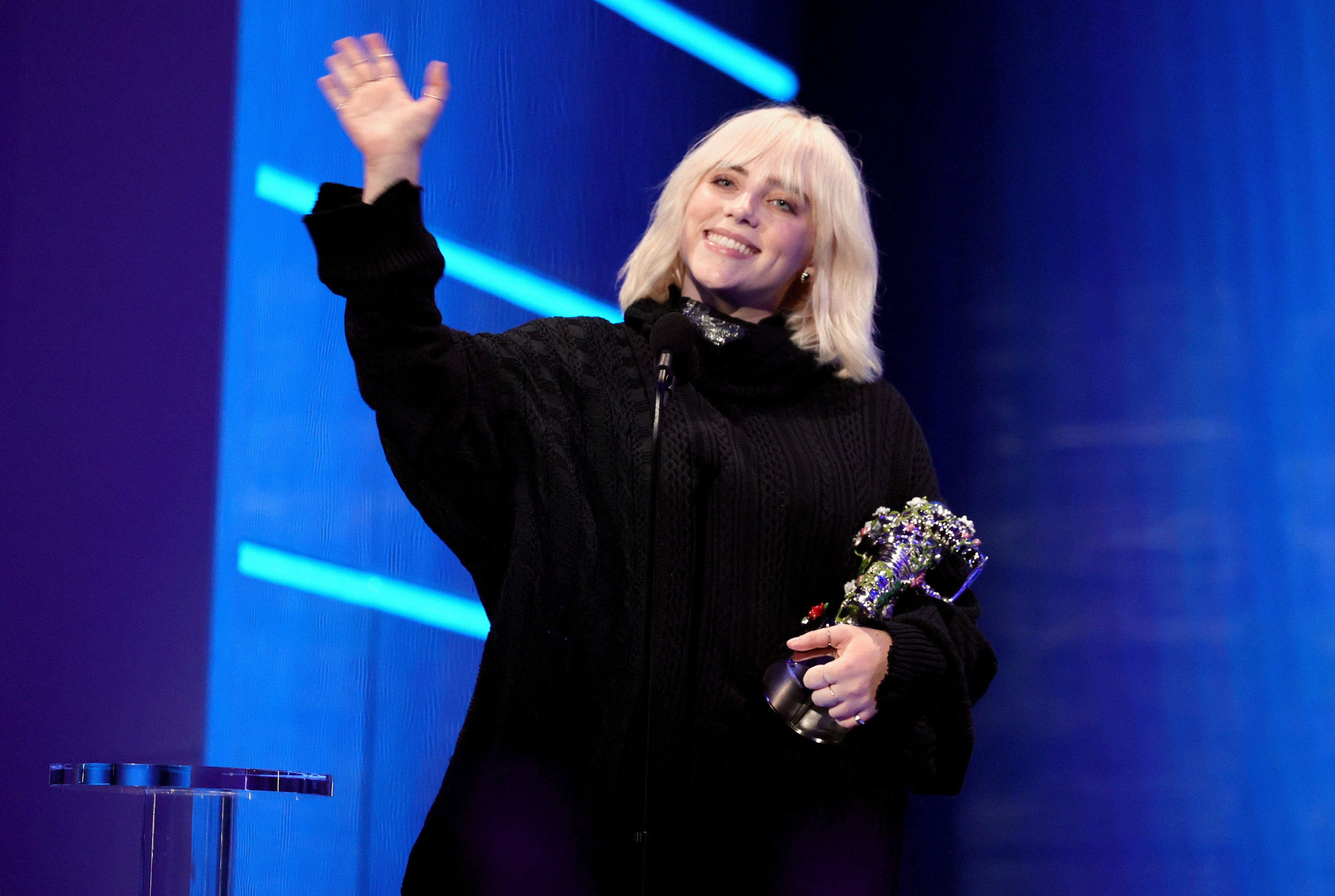 Billie Eilish accepts the Video for Good award for 'Your Power' onstage during the 2021 MTV Video Music Awards at Barclays Center on September 12, 2021 in the Brooklyn borough of New York City. She waves and smiles into the audience.
