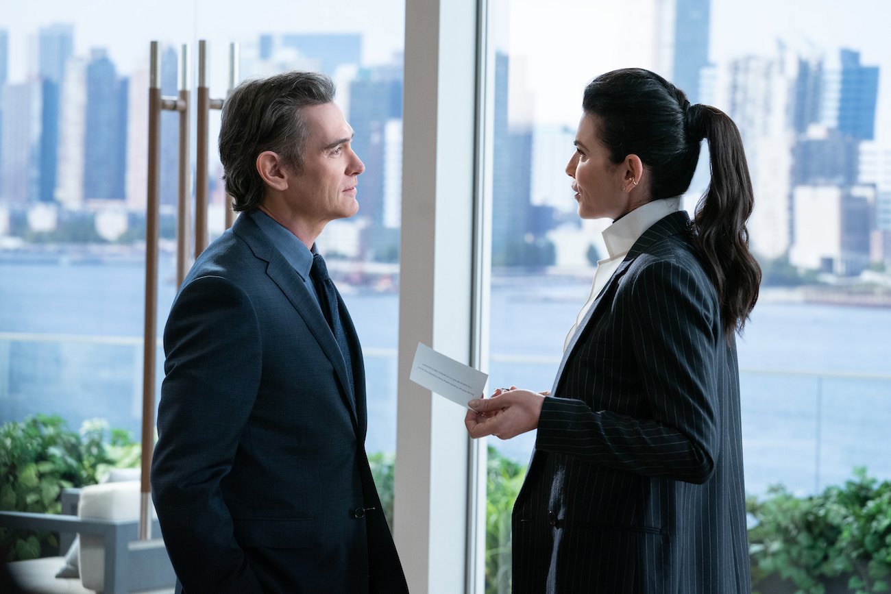 Billy Crudup wears a suit as he looks at Julianna Margulies, also in a suit, in a scene from 'The Morning Show' Season 2