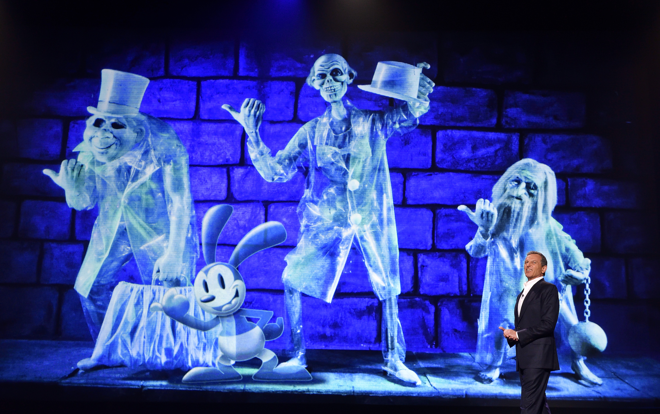 Former Disney CEO Bob Eiger presenting a ghostly screen of the Disney Parks Haunted Mansion ride