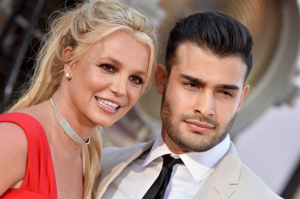 Britney Spears and Sam Asghari smile and pose together at an event.
