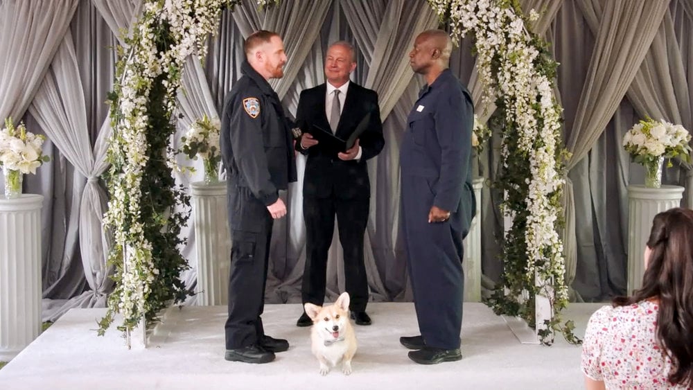 Kevin and Captain Holt stand with their dog Cheddar while renewing their wedding vows in 'Brooklyn Nine-Nine'