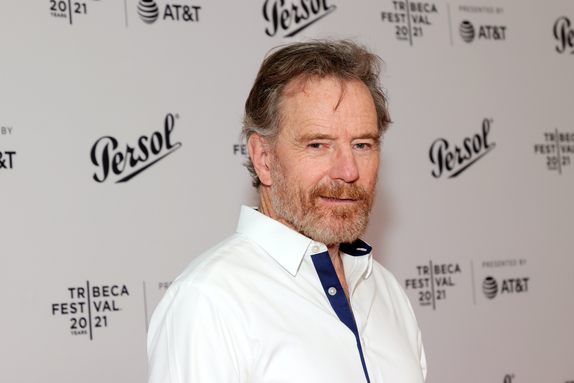 Bryan Cranston smiling in front of a white background