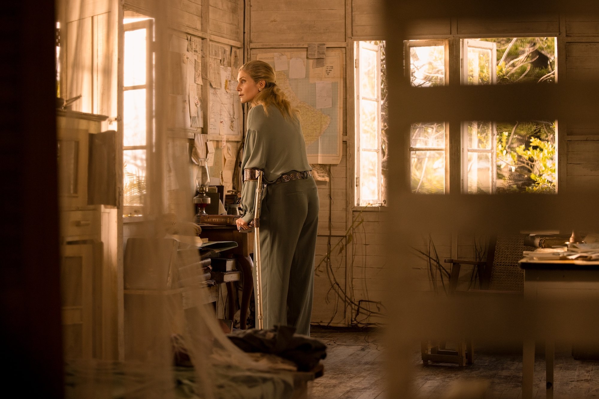 Carla Limbrey, played by Elizbeth Mitchell, looks out of a window in a shack in Barbados in the finale of 'Outer Banks' Season 2