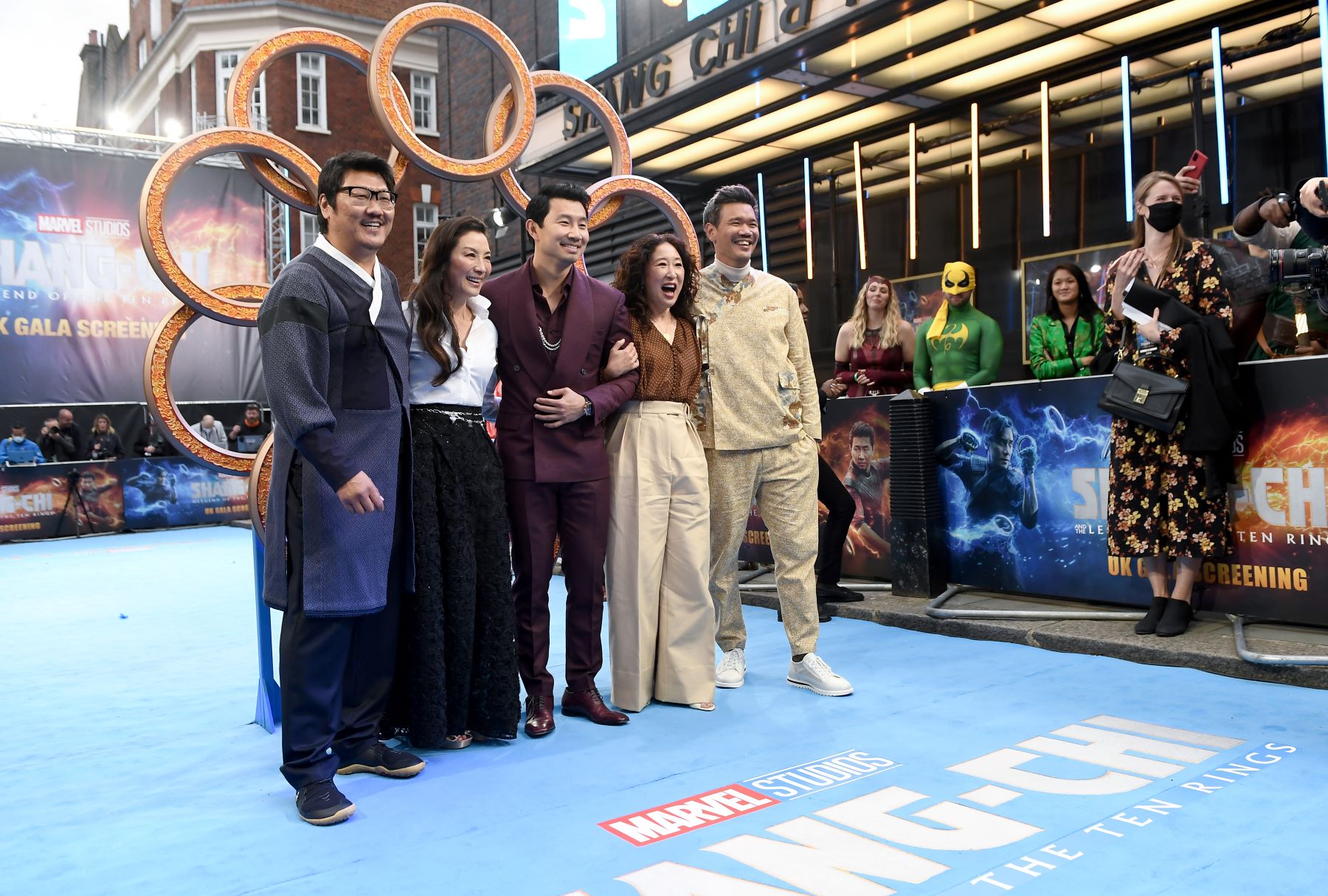 Benedict Wong, Michelle Yeoh, Simu Liu, Sandra Oh and Destin Daniel Cretton wrap their arms around each other and smile for cameras at a screening of 'Shang-Chi and the Legend of the Ten Rings'