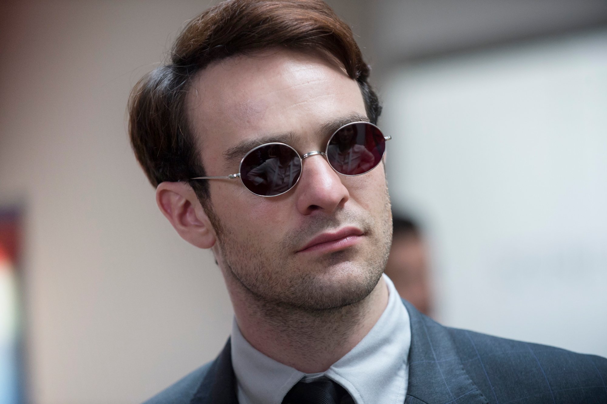 Charlie Cox as Matt Murdock in Netflix's 'Daredevil.' He's wearing dark glasses and a suit. His hair is slicked to the right.
