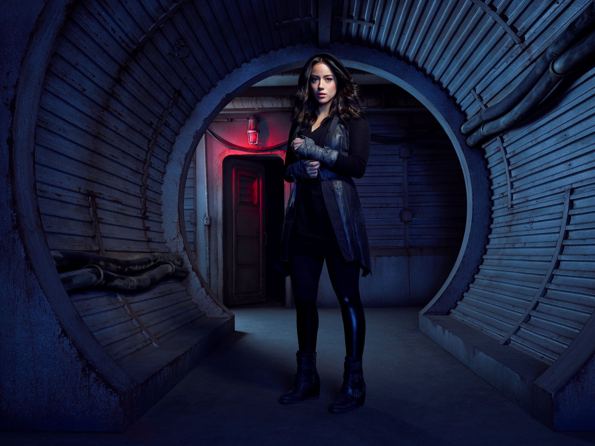 Marvel star Chloe Bennet, who is rumored to be in 'Secret Invasion,' poses as character Daisy Johnson in a tunnel. Bennet is dressed in all black, boots, pants, and hooded jacket.