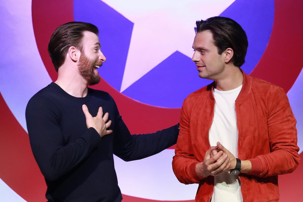 Chris Evans and Sebastian Stan smiling at each other