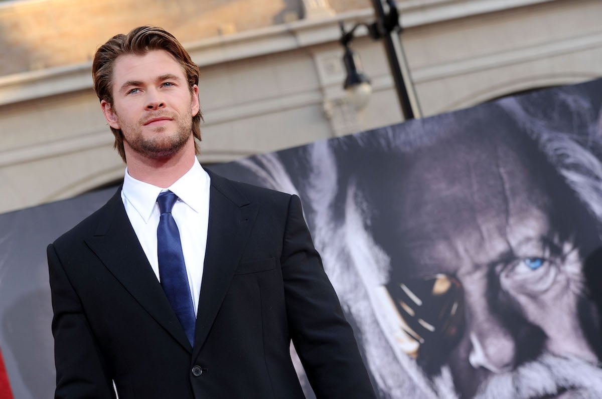 Chris Hemsworth in front of a Thor movie banner