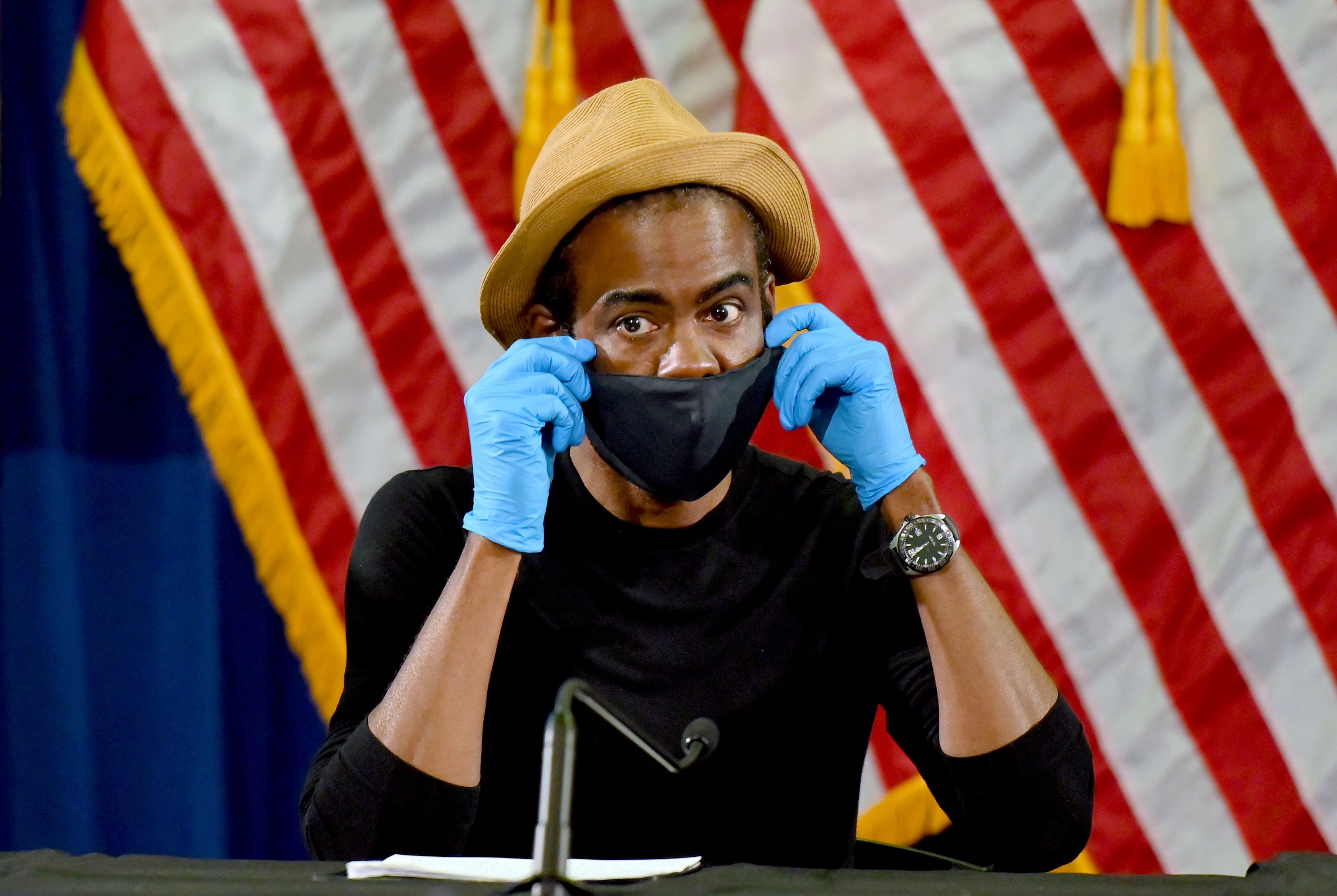 Chris Rock in mask in front of American flag