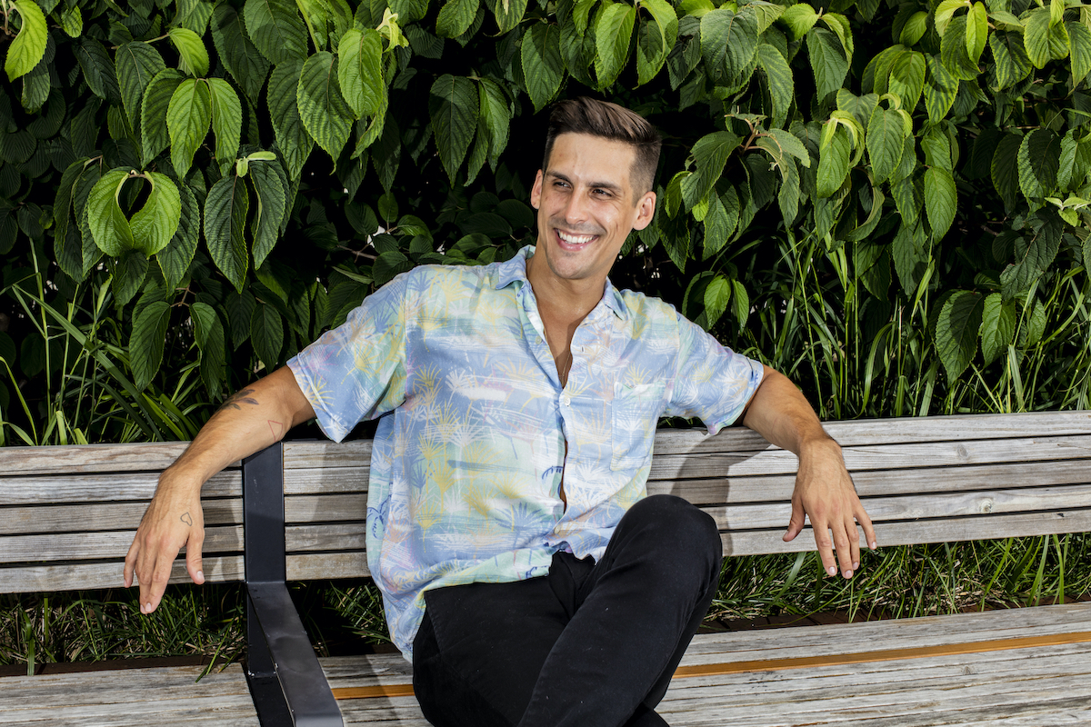 Cody Rigsby smiling, sitting on a bench