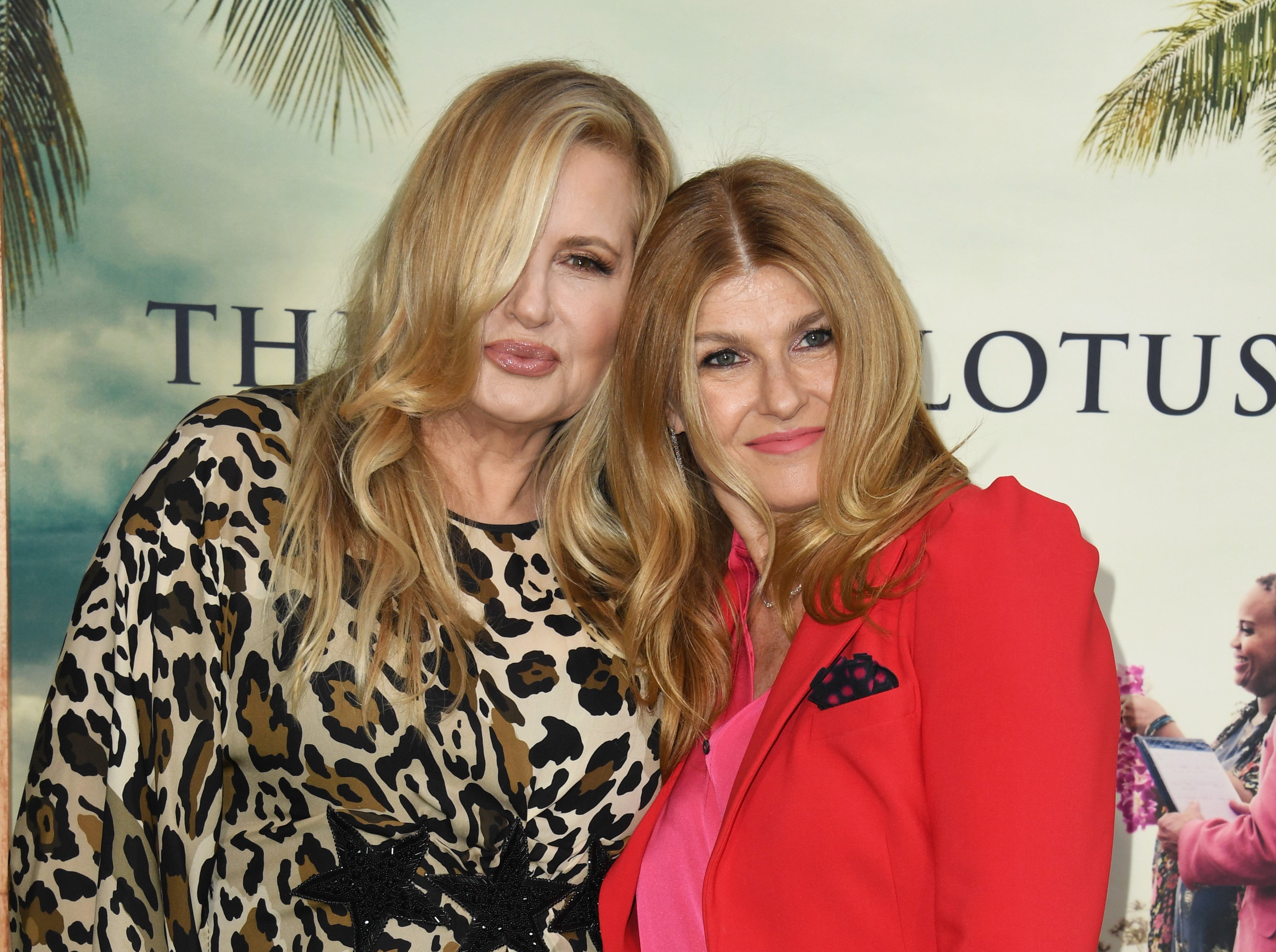 Jennifer Coolidge in a leopard print dress and Connie Britton in a red suit.