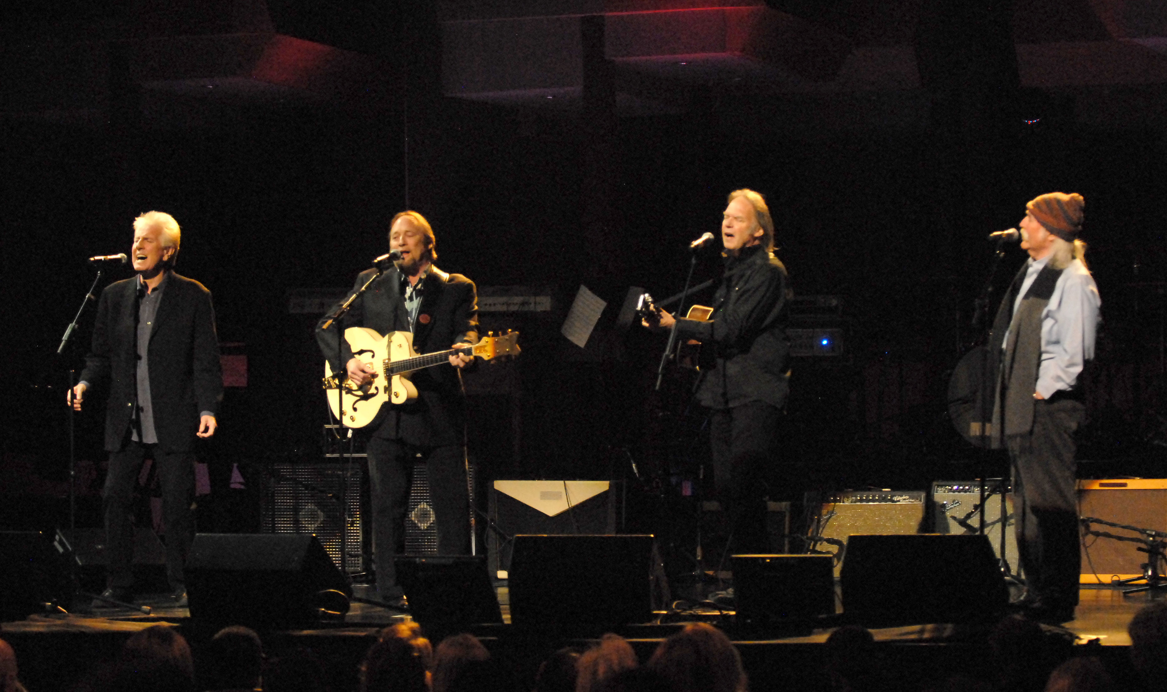 Graham Nash, Stephen Stills, Neil Young, and David Crosby perform onstage. 