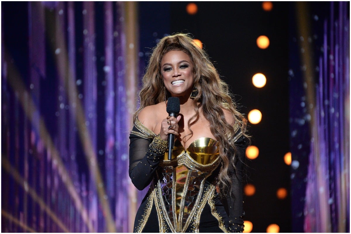 DWTS host Tyra Banks smiling while discussing the competition onstage.