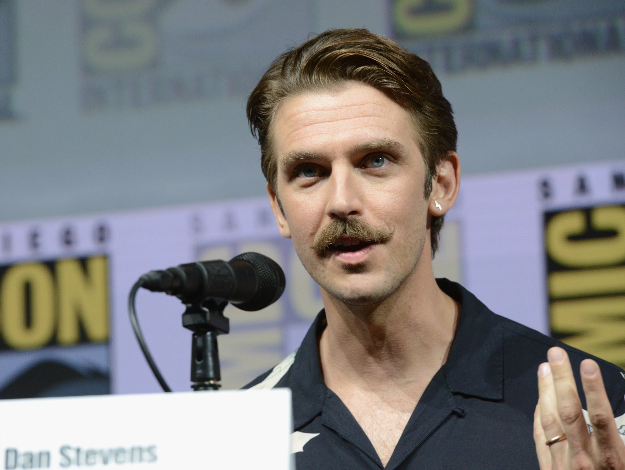 'Downton Abbey' and 'Beauty and the Beast' star Dan Stevens, who is rumored to play a villain in Marvel's 'Eternals.' He's speaking into a microphone during a San Diego Comic-Con panel.
