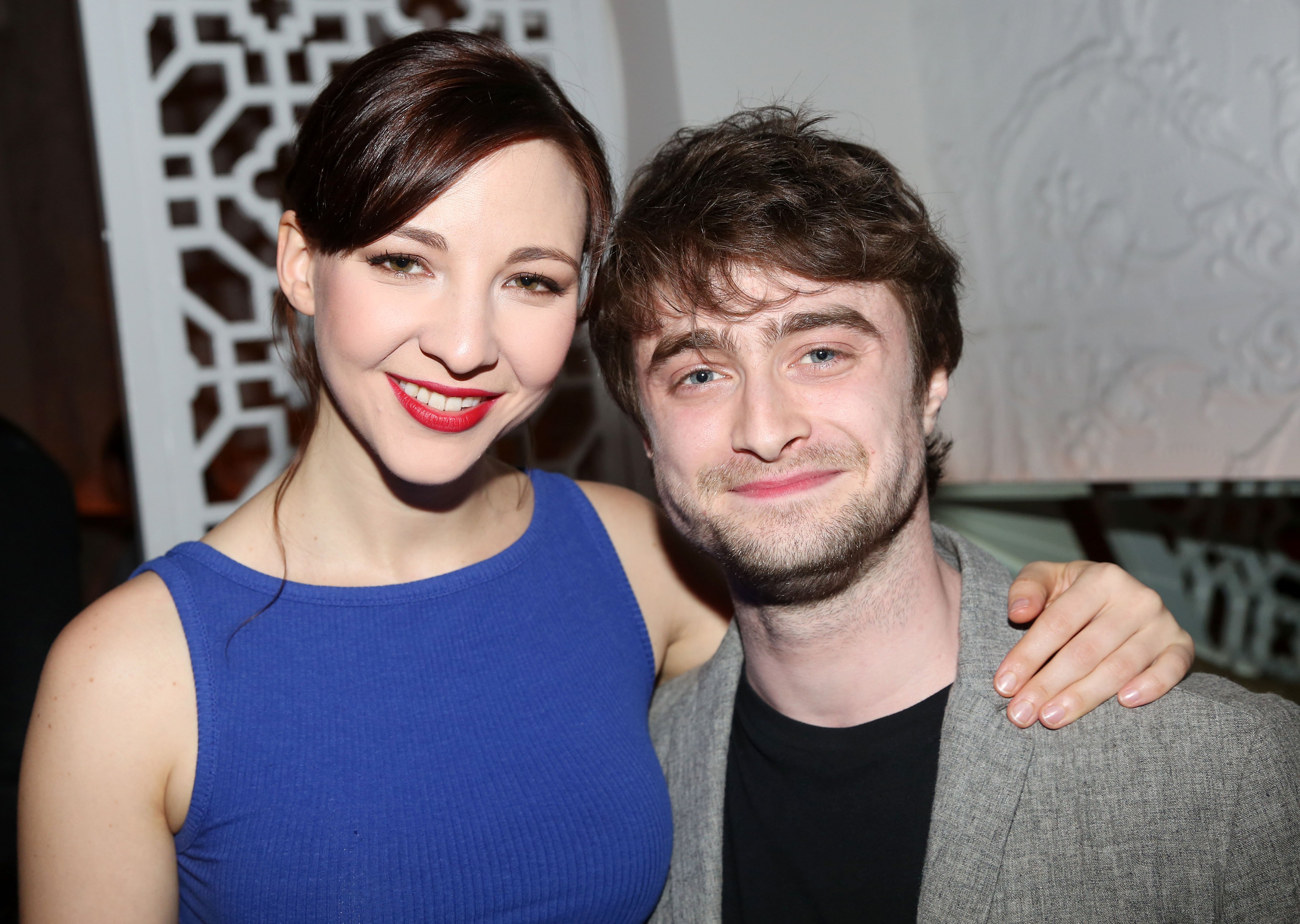 Erin Darke in a blue dress and Daniel Radcliffe in a gray suit.