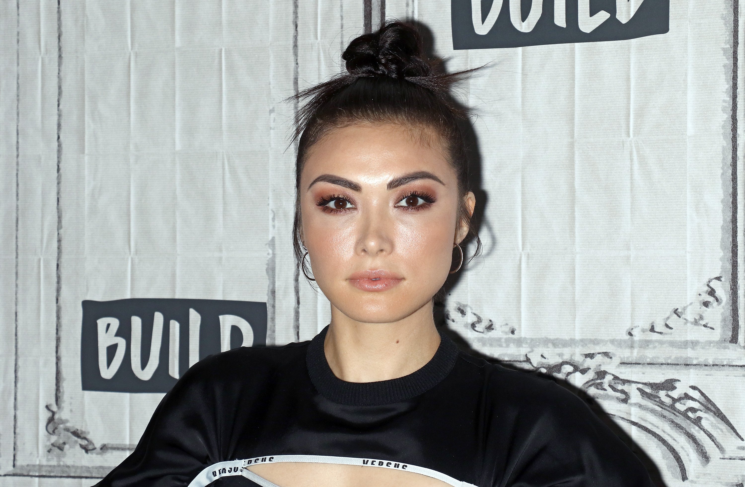 Daniella Pineda 'Cowboy Bebop' wearing black sweater and hair in a bun