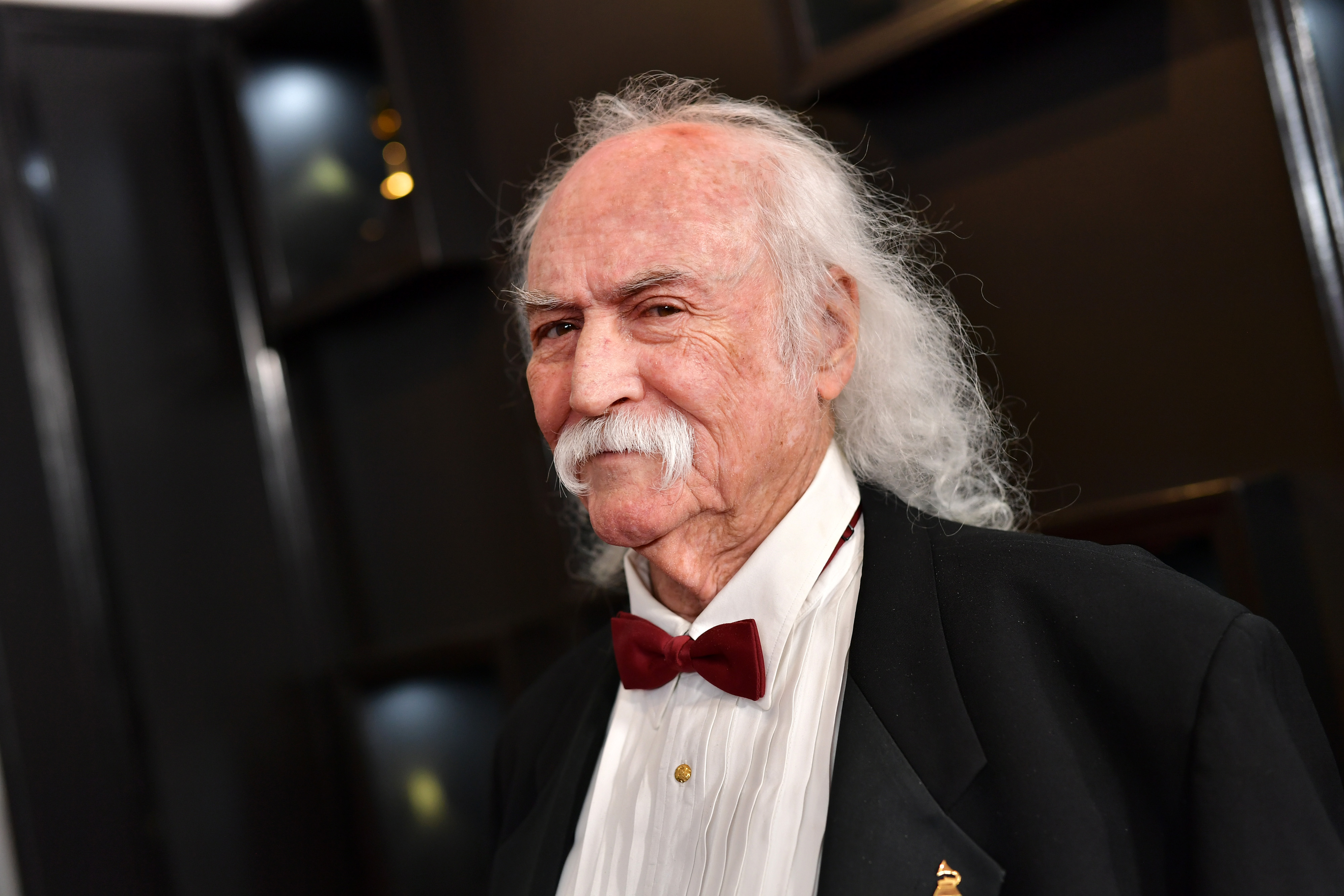 David Crosby in a black tuxedo with a red bow tie. 