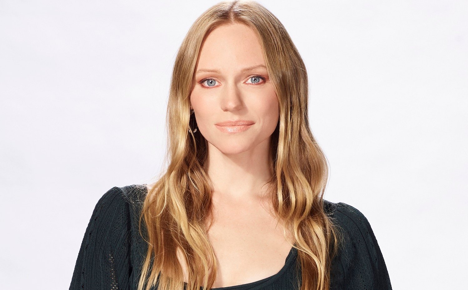 Days of Our Lives star Marci Miller is pictured here in a black scooped neck shirt against a white background