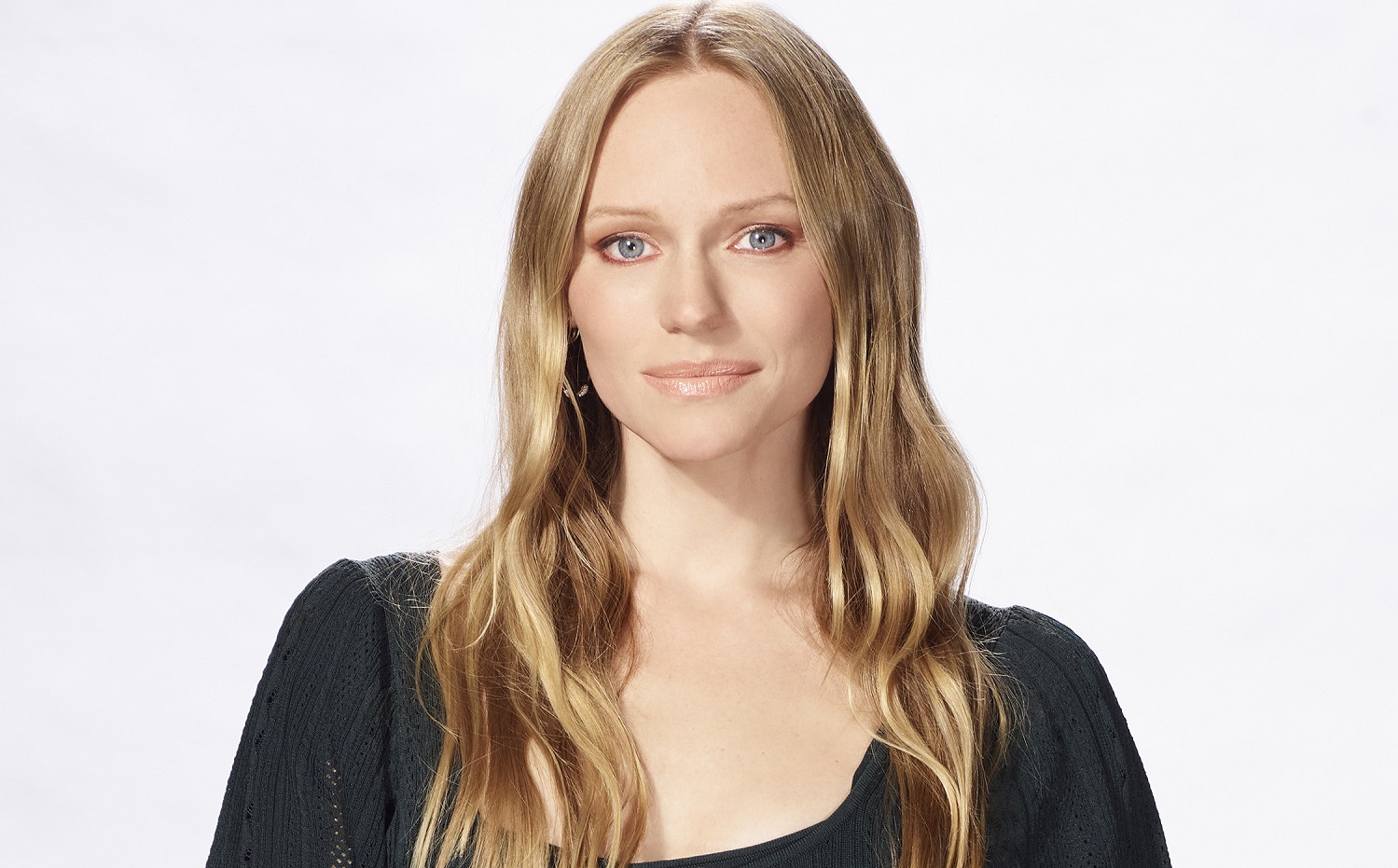 Days of Our Lives star Marci Miller is pictured here in a black scooped neck shirt against a white background