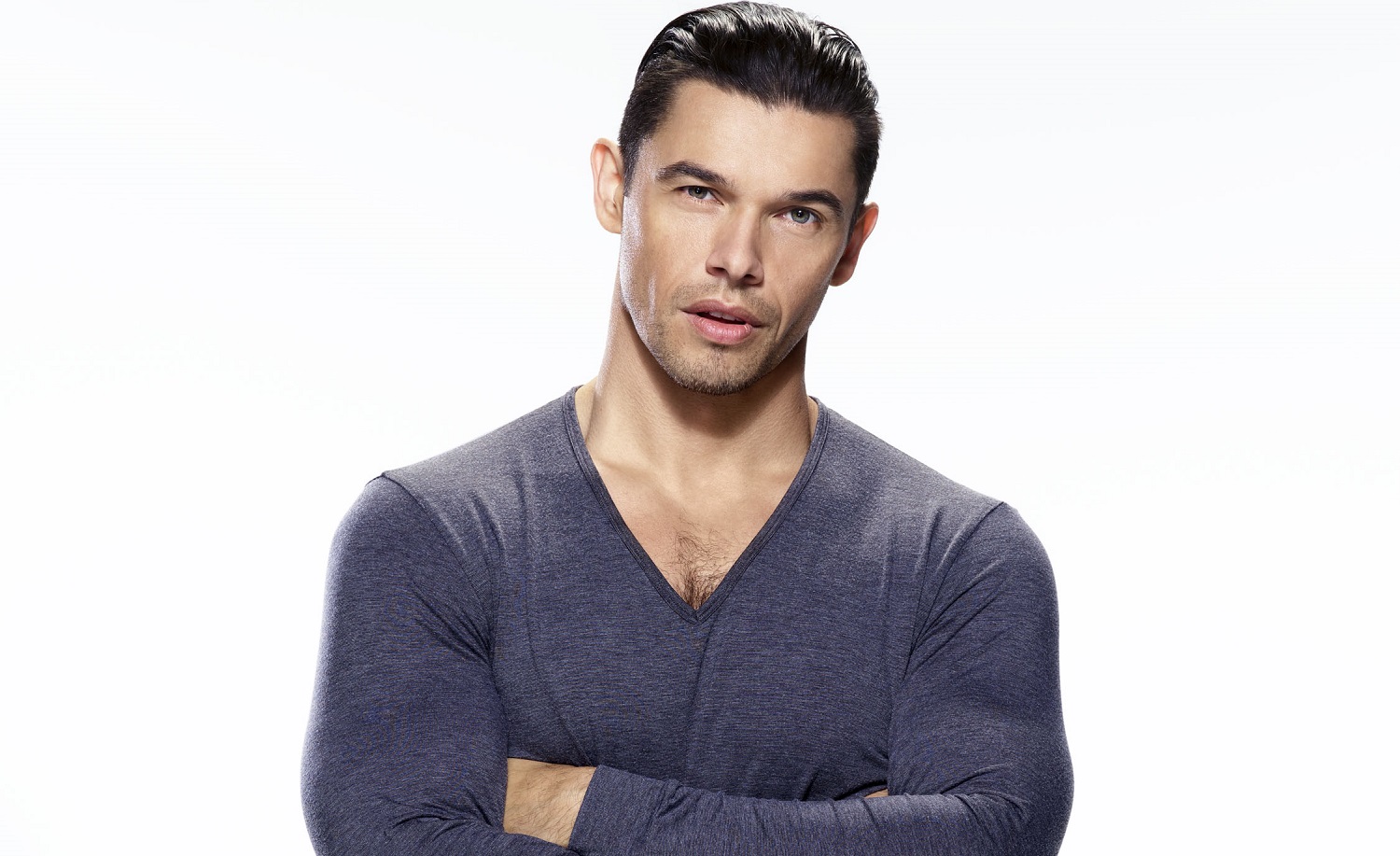 Days of Our Lives speculation has Xander, played by Paul Telfer, pictured here in a blue long sleeved shirt against a white backgroundf