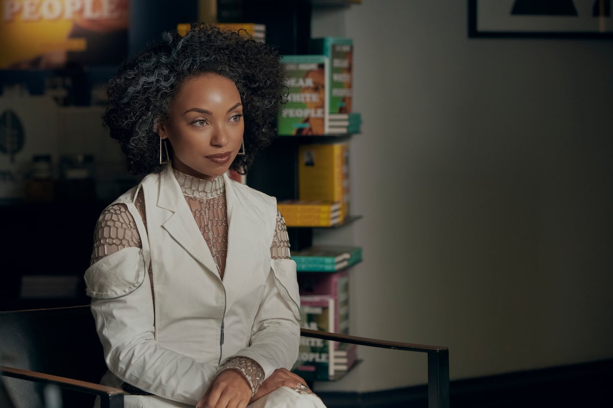 Logan Browning dressed in all-white and sitting as Sam White in 'Dear White People'|