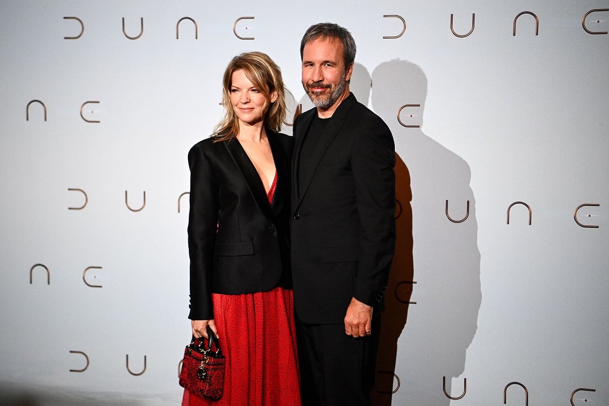 Tanya Lapointe and Denis Villeneuve smile for the cameras while standing in front of 'Dune' display.