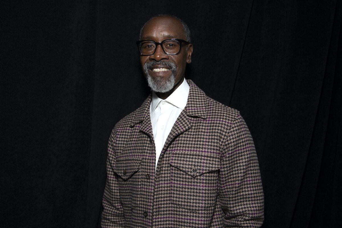 Don Cheadle smiling in front of a black background