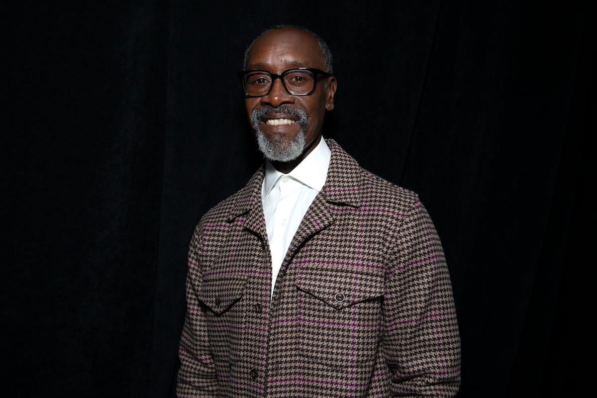 Don Cheadle smiling in front of a black background