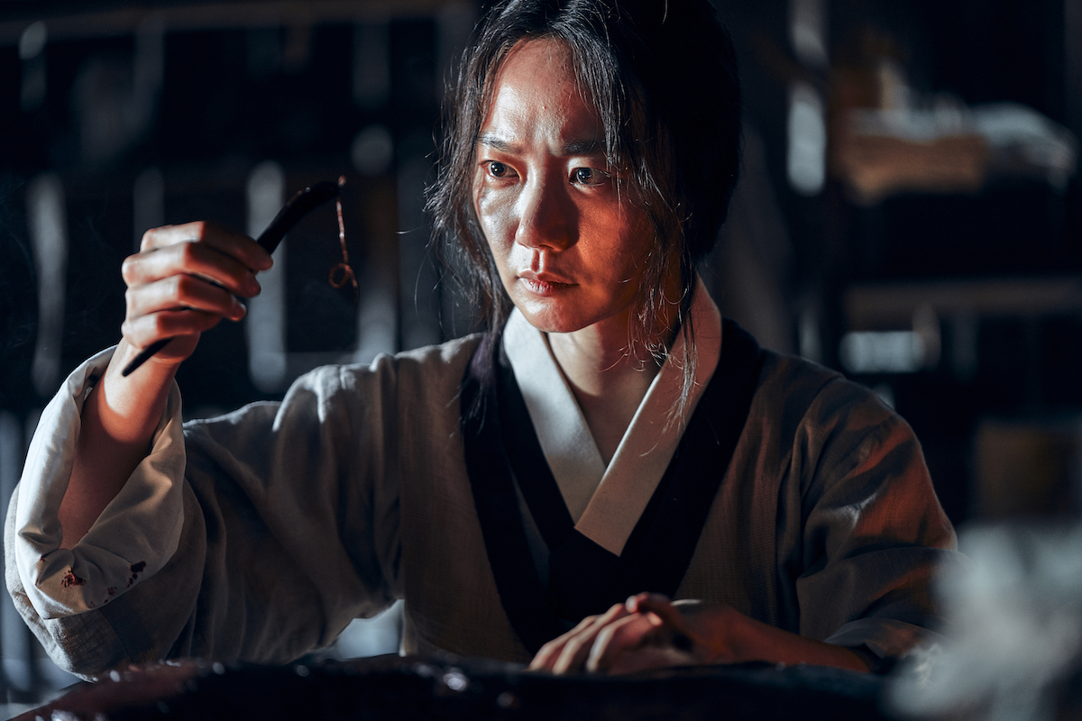 Doona Bae staring at an object in 'Kingdom.'