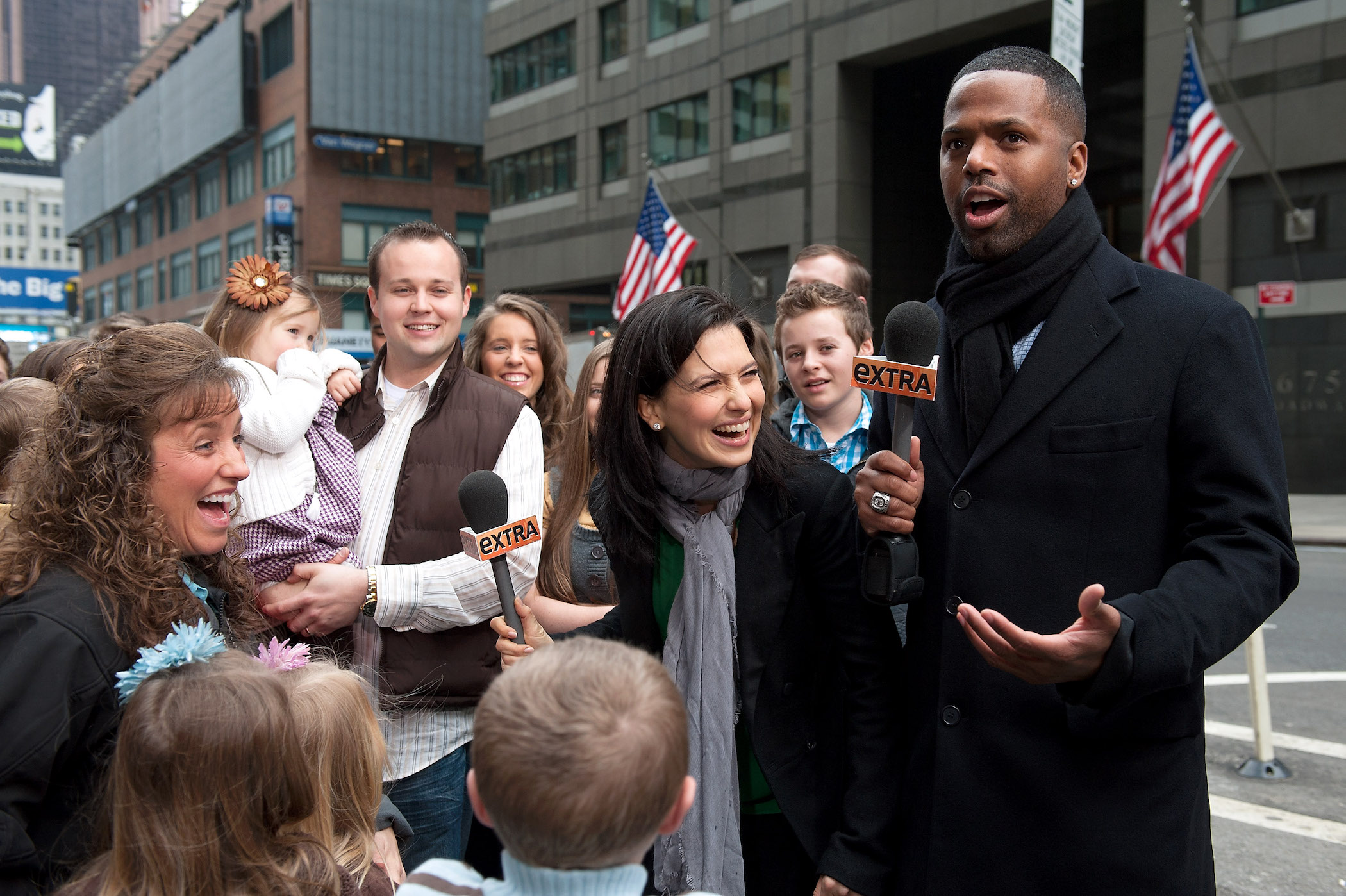 (R-L) AJ Calloway and Hilaria Baldwin interview the Duggar family outdoors. Photo shows Josh Duggar holding his daughter and Michelle Duggar laughing
