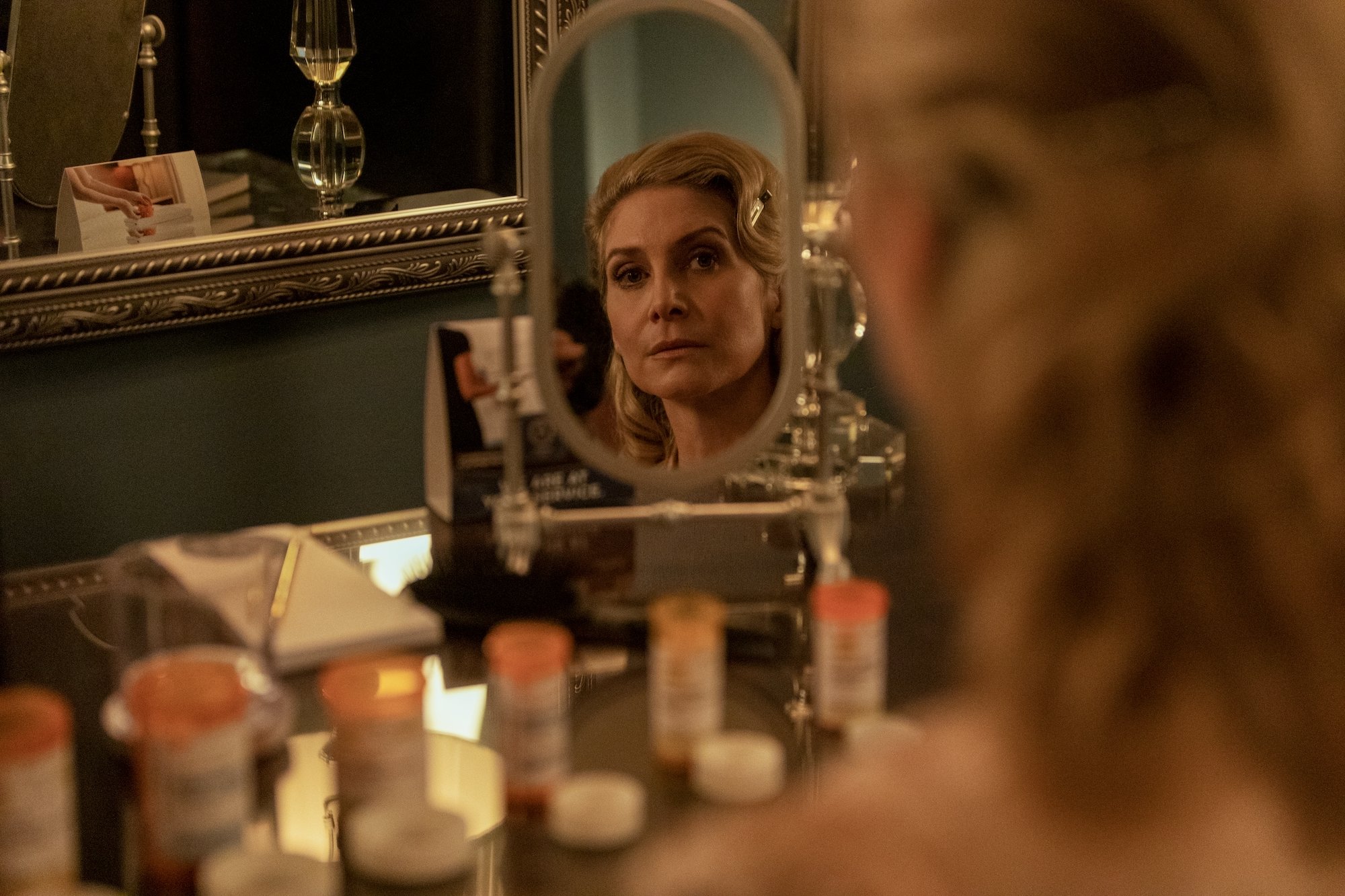 Carla Limbrey, played by Elizabeth Mitchell, looking into a vanity mirror in the Netflix series 'Outer Banks'