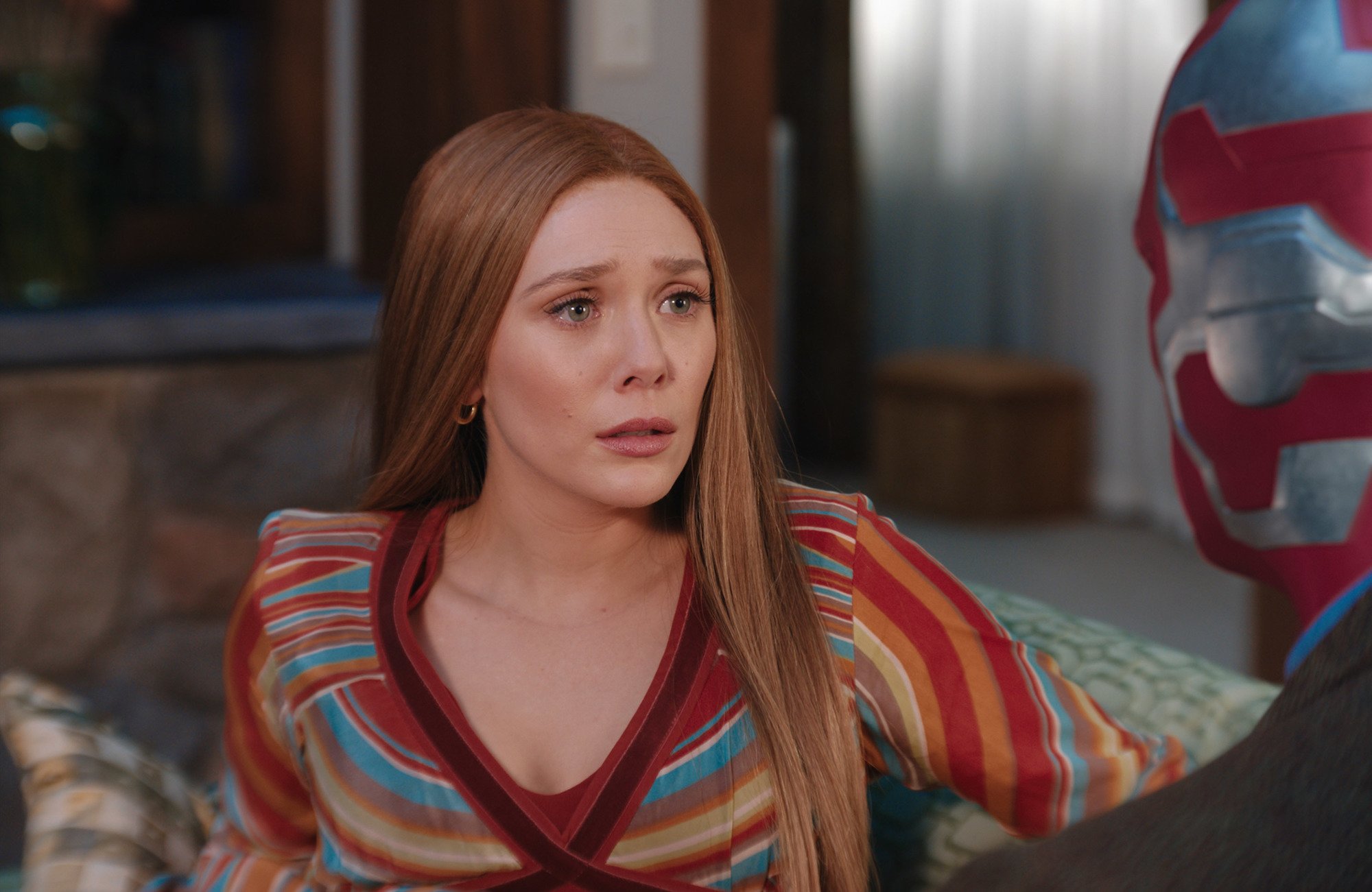 Elizabeth Olsen sitting on a couch in 'WandaVision'