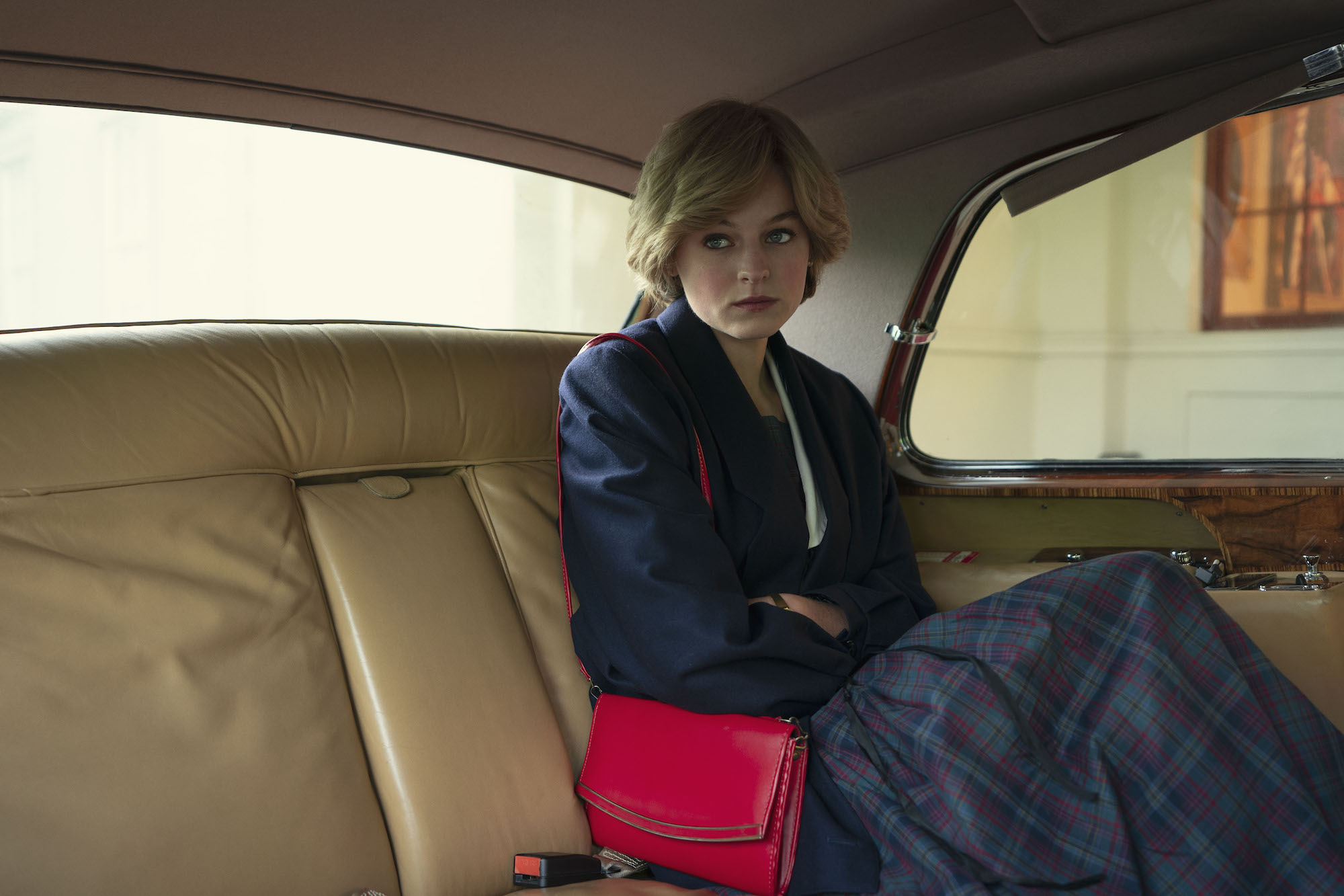 Emma Corrin as Princess Diana sitting in the back of a car in 'The Crown.'